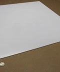 Virgin PTFE Sheet One Eighth Inch Thick By Twenty Four Inch By Twenty Four Inch Industrial Grade High Purity on brown surface.