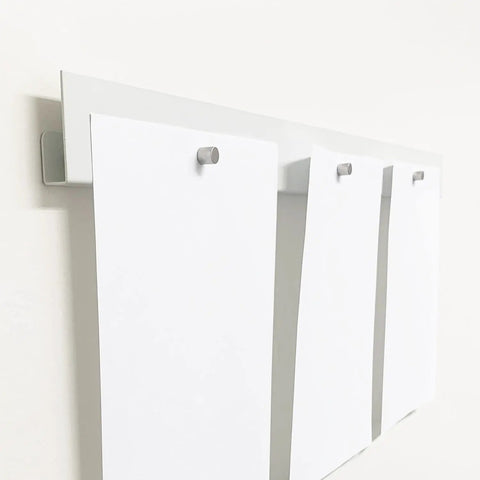 White Magnetic Wall Display Bars For Kid Art And Photos Strong Magnet Gallery Track System Total Flex Spacing Setup showing three papers held on a steel rail.