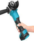 Rock Solid Electric Angle Grinder Tearing Through Metal And Wood With Knockout Torque And Adjustable Safety Guard For Smooth Cutting Grinding Polishing Plus Deep Grip Auxiliary Handle In Classic Blue Black in use with a hand gripping the auxiliary handle.