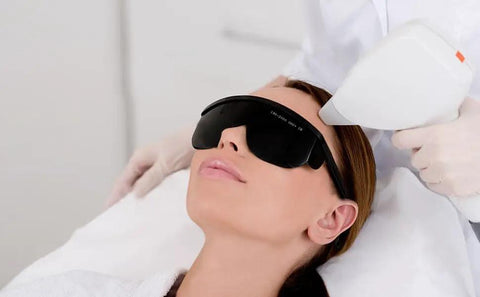 Legit Heavy Duty IPL Laser Safety Glasses With Solid Eye Protection And Broad Spectrum Shielding Against Ultraviolet Blue Light And Infrared Beams For Laser Hair Removal Treatment on a woman during a procedure.