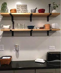 Heavy Duty Industrial Floating Shelf Wall Brackets For True 10 Inch Lumber Boards Built Like A Tank Forged Steel Bracket Set With 1 Inch Front Lip For Any Solid Home Makeover Project holding wooden shelves with various kitchen items.