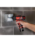 Heavy Hitter Cordless Compact Rotary Hammer Drill Driver Kit using variable speed to drill into concrete box.