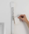 Top Tier Blind Strap Replacement Kit For Retractable Window Coverings with heavy duty grey straps attached to a wall during installation.