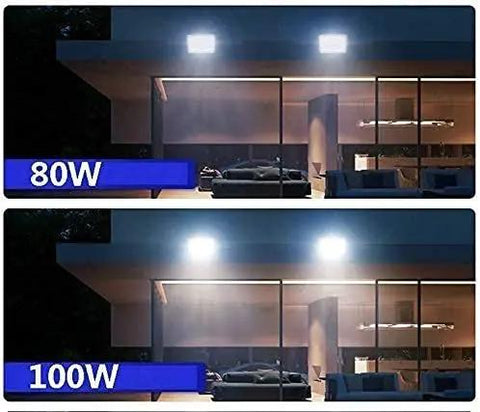 Badass Solar Led Flood Light With Advanced Motion Sensor IP66 Waterproof Outdoor Security Fixture Tough As Nails Die Cast Aluminum Build For Fences And Patios Super Bright Daylight White 80W and 100W comparison in outdoor setting.