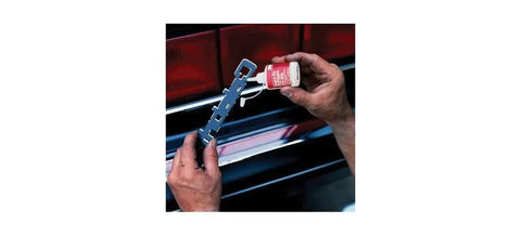 Hands holding Killer Strength Quick Fix Super Adhesive For Plastic Metal Glass Auto Marine Applications with metal tool on a car.