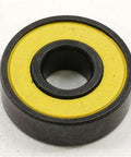 5 Sets = 40 Skateboard Bearing close-up of black skateboard bearing with yellow seal, nylon cage, and carbon steel material