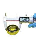 Top Shelf 6205 Hybrid Ceramic Ball Bearings Si3N4 Balls Steel Rings measuring 52mm diameter with caliper tool.