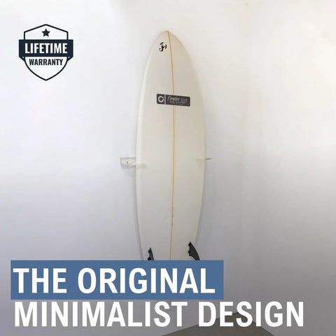 Heavy Duty Vertical Surfboard Wall Mount Rack Made From Crystal Clear Acrylic displays a surfboard against a white wall.