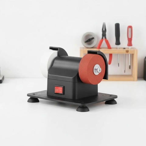 Compact Bench Top Grinder With Rock Solid Base Dual Sharpening Wheels on a workbench, showcasing white and red grinding wheels.