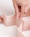 Hands assembling Hella Smooth Honeycomb Drawer Organizer For Closet That Fits Like A Glove And Frees Up Major Space Using Sturdy Abs Plastic Grids.