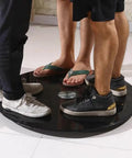 Smooth As Butter Black Tempered Glass Lazy Susan Turntable with feet standing on the rotating tray.