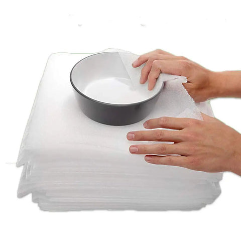 Top Shelf Foam Packing Sheets 100 Pack 12X12 Inch 1/16 Thick Polyethylene Non Abrasive Dust Free Protective Padding For Moving Shipping Storage Heavy Duty Cushioning Boxes And Totes with bowl being wrapped.