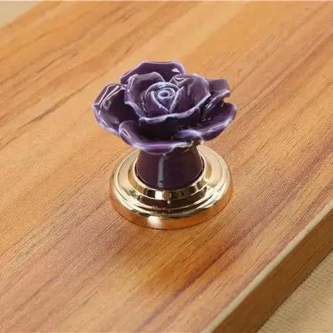Set Of Ten Vintage Ceramic Rose Cabinet Knobs With Gold Plated Base For Kitchen Drawers And Cupboard Doors. Purple ceramic rose knob on wood.