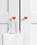 Solid 2 Piece Round Cabinet Knobs Crafted From Fine Beech Wood With Abstract Oil Painting Finish on white cupboard with bag.