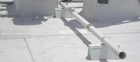 36-inch white PVC rooftop support resting on two ROOFTOP blocks on a flat roof