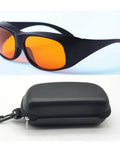 Badass Laser Safety Goggles For Blue And Green Beams Rock Solid Optics With Optical Density Five Shielding For Workshop Tasks And Precision Cutting in black with orange lenses and carrying case.