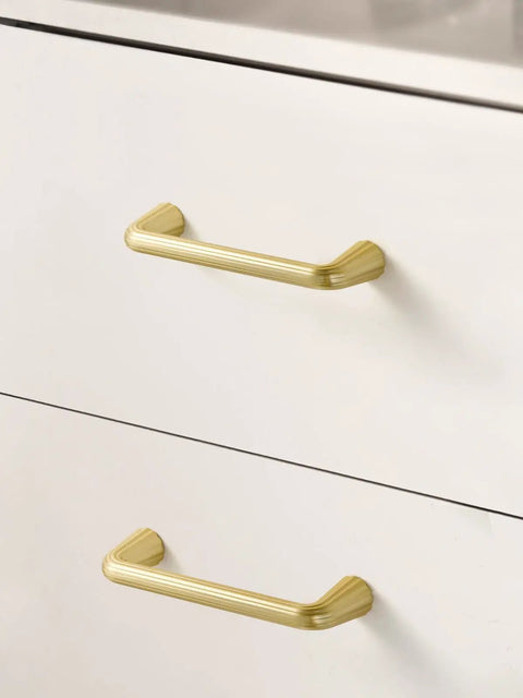 Super Slick 5 Pack Gold Cabinet Pulls With Brushed Brass Finish on white drawers, highlighting modern design and durability.