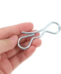 Hand holding a clip from Cotter Pin Assortment Kit With Bow Tie Locking Clips And Heavy Duty Trailer Hitch Pins For Lawn Mower And Truck Deck Hardware 2 Sets Of 5 Precision Fastening For Stable Easy Maintenance