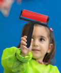 3 Piece Manual Stamping Ink Roller Kit Featuring A Super Silky Smooth Cylinder And Rugged Red Plastic Handle held by a child.