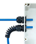 Waterproof cable gland with PG7 thread installed in electrical box; black PA66 plastic, blue cables.