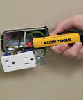 Hand using yellow non-contact voltage tester pen on wall outlet, part of the AC Circuit Breaker Kit With GFCI Digital Circuit Breaker Finder