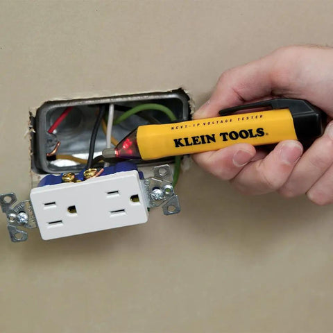 Hand using yellow non-contact voltage tester pen on wall outlet, part of the AC Circuit Breaker Kit With GFCI Digital Circuit Breaker Finder