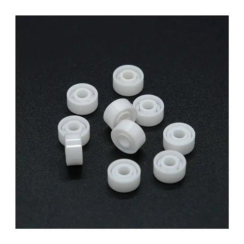 Top Shelf Zirconia Ceramic Ball Bearings Built Solid For Demanding Workshops, ten white ceramic balls on a black background.
