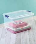 Six Pack Of 66 Quart Clear Plastic Storage Containers With Sleek Blue Latching Lids Designed For Heavy Duty Stackable Organization And Hassle Free Clutter Control In Your Living Room Or Home Office, featuring stacked blankets inside a clear bin.