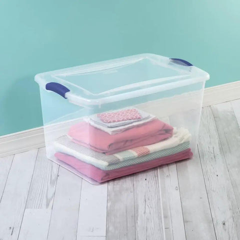 Six Pack Of 66 Quart Clear Plastic Storage Containers With Sleek Blue Latching Lids Designed For Heavy Duty Stackable Organization And Hassle Free Clutter Control In Your Living Room Or Home Office, featuring stacked blankets inside a clear bin.