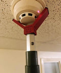Rock Solid Dual Magnet Smoke Detector Test Tool For Fire Safety Systems With Quick Pole Thread Adapter and Duct Activation Features mounted on a smoke alarm.