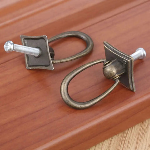 Two Piece Ring Handle Antique Bronze Pull With Screws For Drawers Doors Cabinets Or Vintage Chests Easy To Install Adds That Classic Rustic Retro Vibe To Kitchen Living Room Bedroom And More on wooden surface
