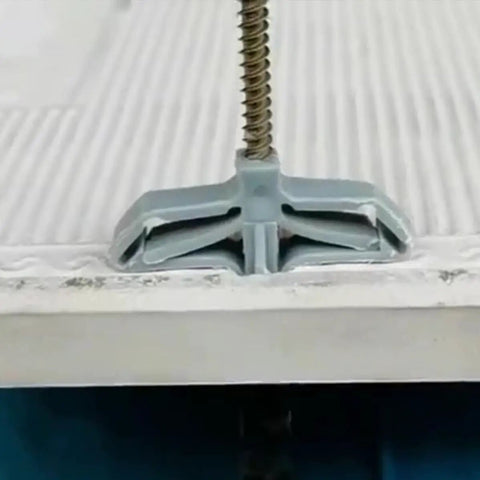 Close-up of 400 Piece Drywall Anchors Kit Self Drilling Butterfly Shaped Anchor in gypsum board showing expansion design.