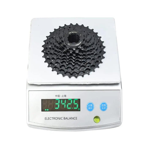 9 Speed Bike Cassette 11-25T 11-32T 11-36T 11-40T for mountain and road bikes on electronic scale showing 342.5 grams.