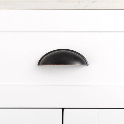 Three Inch Oil Rubbed Bronze Cup Pulls For Cabinets And Drawers Solid Metal Hardware 10 Pack Includes Matching Screws shown on a white cabinet.