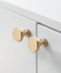 10 Pack Brushed Brass Cabinet Knobs 1-1/4 Inch Gold Drawer Knobs installed on white kitchen cabinet doors.
