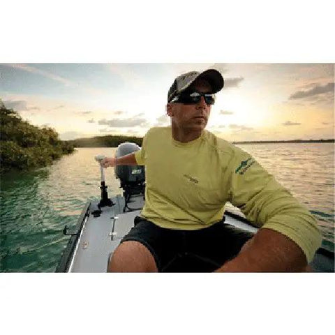Man on a fishing boat using a Rock Solid Transom Mount Electric Trolling Motor With Telescoping Tiller and Digital Maximizer.