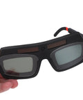 Auto Darkening Welding Safety Glasses PC Wraparound Sweet Clarity Hard To Beat At The Big Box Store held in hand showing the dark lenses.