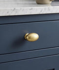 Top Shelf Champagne Bronze Cabinet Knobs With A Hammered Oval Dome and Soft Metallic Luster on blue drawer, quick install.