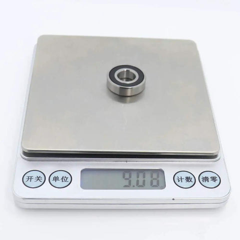Four Pack 440C Stainless Steel Ball Bearings 10x22x6mm ABEC 3 Rubber Sealed Heavy Duty Rotating Rings on a scale.