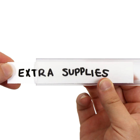 Hand inserting a label into Slick Clear Plastic Shelf Clip Label Holders Fits One Inch Thick Racks No Sweat Installation.