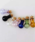 Colorful glass potion bottles with cork stoppers for crafts, featuring purple, black, clear, pink, blue, green, and yellow designs.