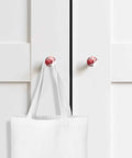 Two Piece Set Top Shelf Solid Beech Wood Round Cabinet Knobs Showcasing Dope Abstract Red And Fresh Sage Green Graffiti Art on white cupboard.