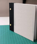 20 Pack Of Chicago Screw Posts With 10mm Brass Plated Finish Ideal For Scrapbooking Photo Album Binding and Leather Craft Repair, shown binding a scrapbook.