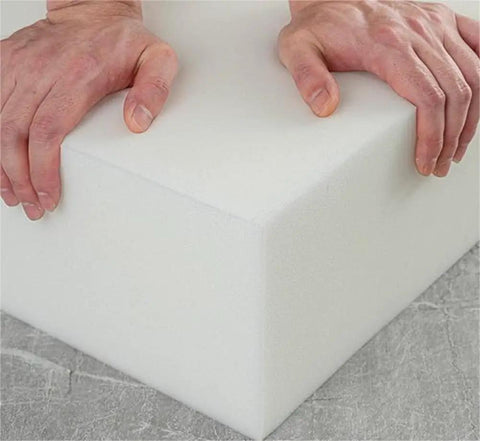 Hands pressing on a 2 Pack White High Density Foam Sheets For Furniture Reupholstery And Diy Crafts, two inch thick foam slat.