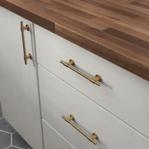 Top Shelf 10 Pack Adjustable Cabinet Handles In Elegant Champagne Bronze Finish on white kitchen drawers with wooden countertop.