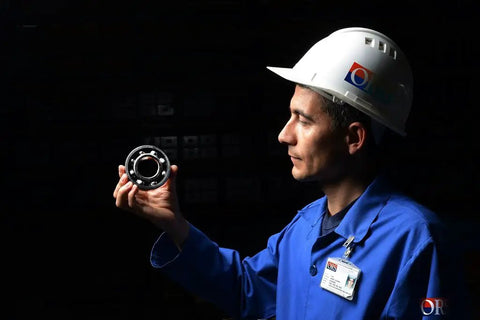 Heavy Duty Single Row Deep Groove Ball Bearing With Dual Seals And Steel Retainer Featuring C3 Radial Clearance And ABEC 1 Precision held by a worker.