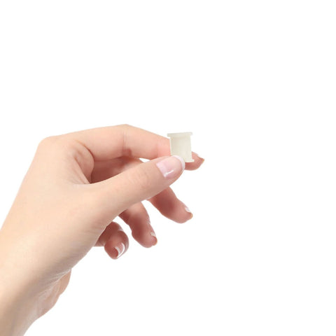Close-up of a person holding a light-yellow plastic caster socket insert from the 10-pack, swivel caster stem sleeves for office chair feet.