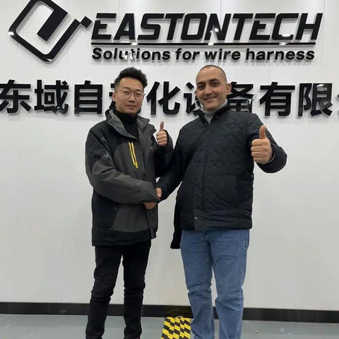 Two professionals shaking hands in front of EASTONTECH sign, discussing Precision Rotary Wire Stripping Machine that eats 8mm2 cables.
