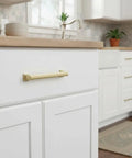 Give Your Home a Chic Glow Up with These Epic Brushed Gold Cabinet Pulls Hardware 10 Pack 5 Inch Handles for Kitchen Cabinets Drawers and Wardrobes Solid Metal Fit on white cabinet drawer.