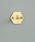 Top Shelf Brass Wall Hooks For Towels And Mugs No Sweat Rust Proof Bathroom Hanger on a grey wall, hexagonal design.